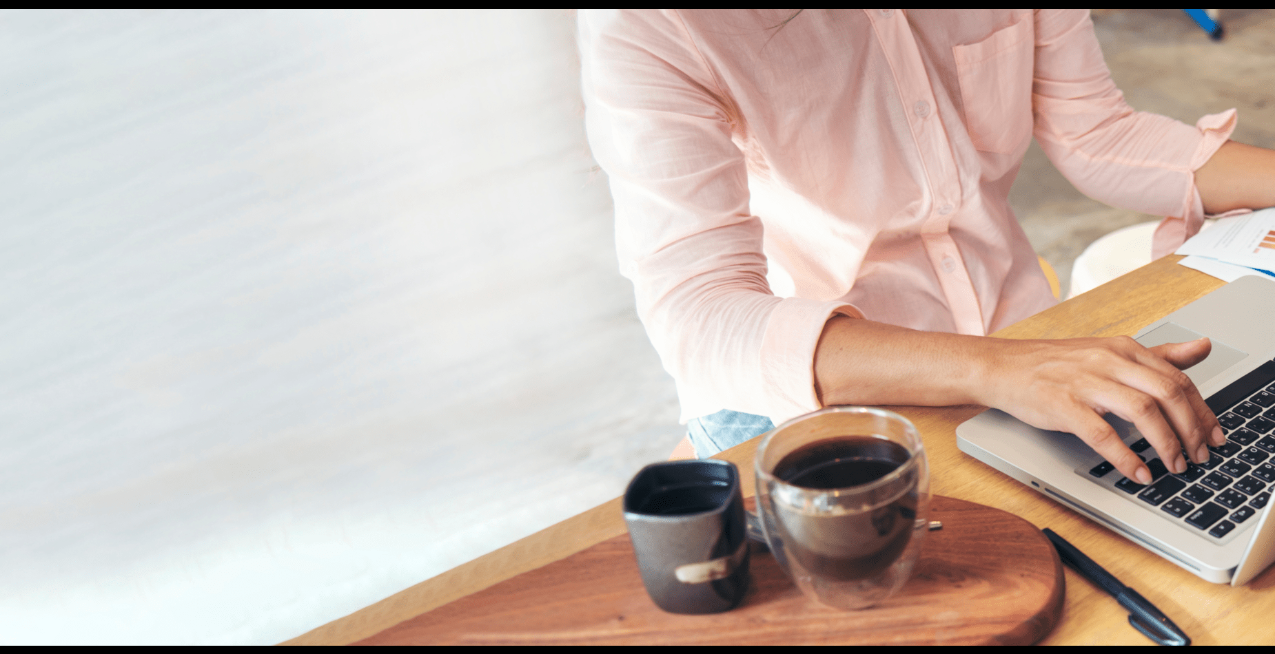 Person working on laptop with coffee.