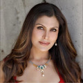 Woman with long brown hair wearing a necklace.