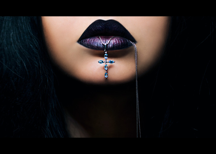 Woman with dark lips and a cross necklace.