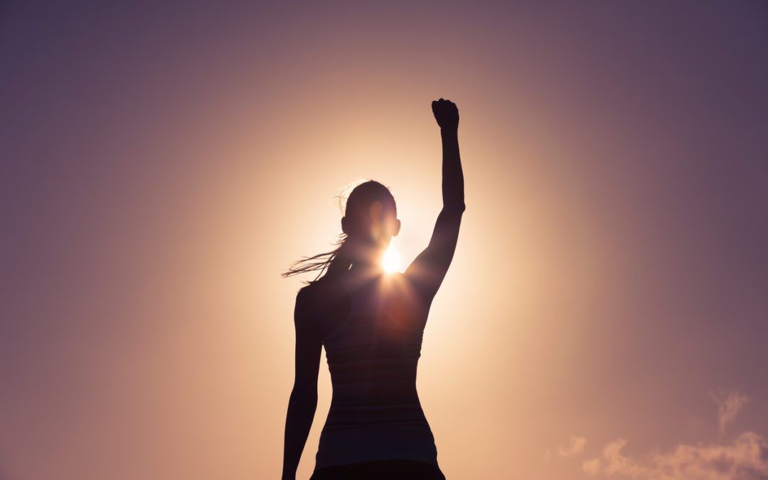 Silhouette of a woman raising her fist.